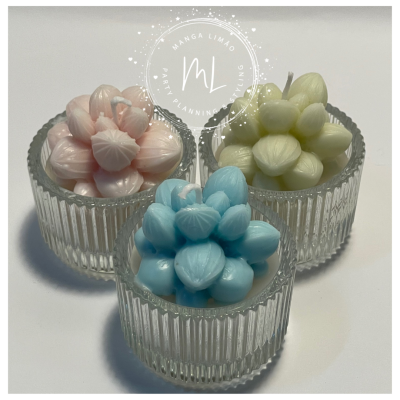 Três velas decorativas coloridas em copos de vidro texturizados