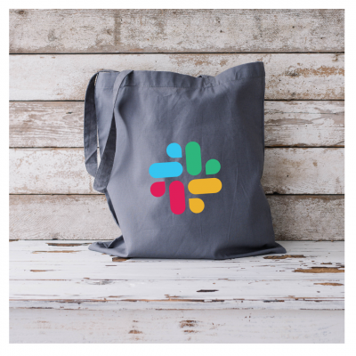 Saco de tecido cinzento com logótipo colorido sobre superfície de madeira