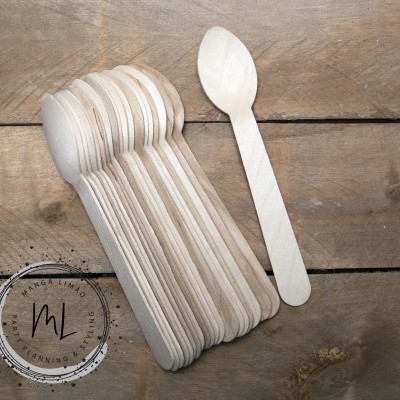 Conjunto de colheres descartáveis de madeira clara empilhadas sobre superfície de madeira com selo