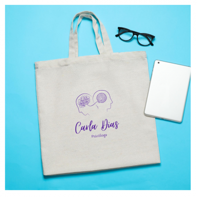 Mala de tecido bege com impressão roxa e acessórios tecnológicos sobre fundo azul