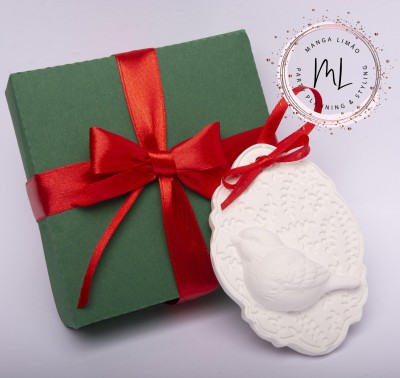 Caixa de presente verde com fita vermelha e decoração branca com relevo de pássaro e padrão floral