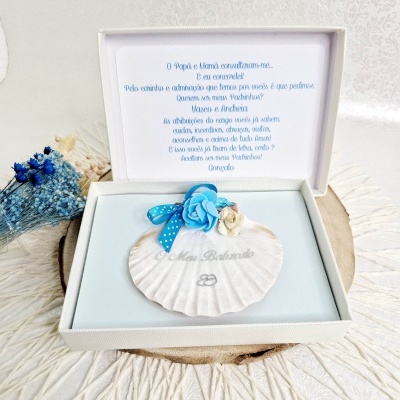 Concha decorativa com flores dentro de caixa branca aberta