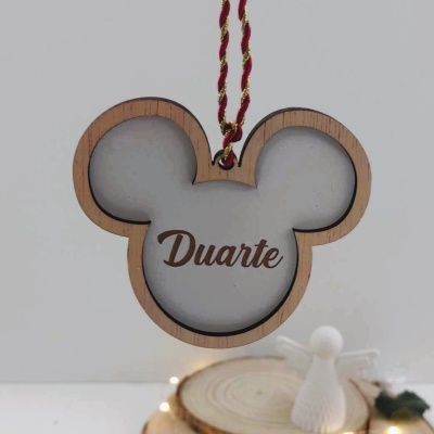 Ornamento pendente em forma de cabeça de rato com nome Duarte gravado.