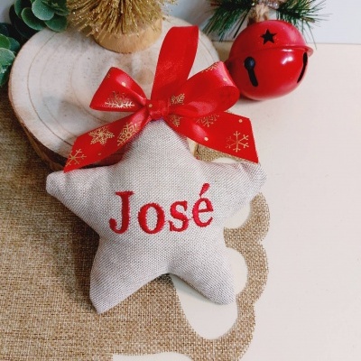 Almofada estrela bege com nome José bordado a vermelho e laço vermelho decorativo