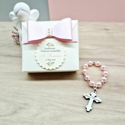 Caixa branca decorativa com laço rosa e terço rosa com cruz branca em madeira.