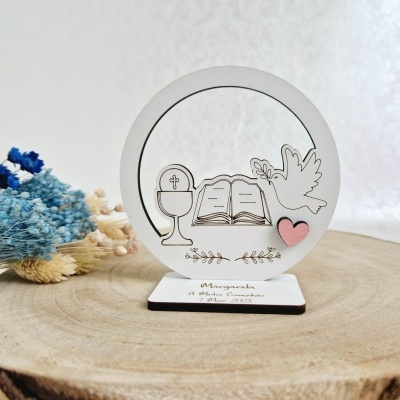 Decoração em madeira branca redonda com símbolos religiosos gravados e base personalizada sobre tronco de madeira