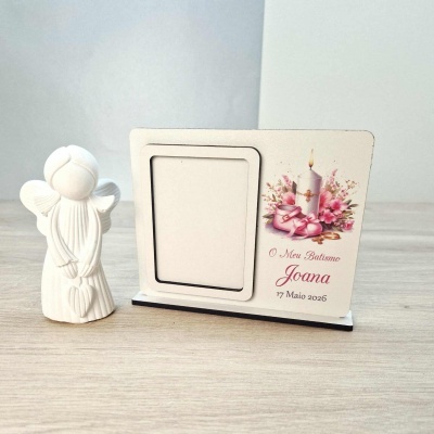 Anjo branco e porta-retratos de batismo com vela, flores e sapatinhos rosa