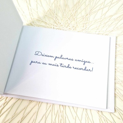 Livro aberto com frase em azul sobre página branca e fundo texturizado claro