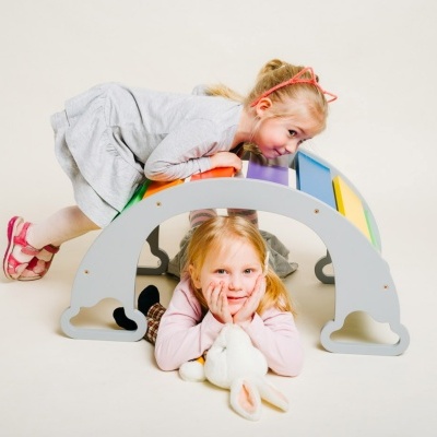 Brinquedo arco-íris de madeira com crianças a brincar