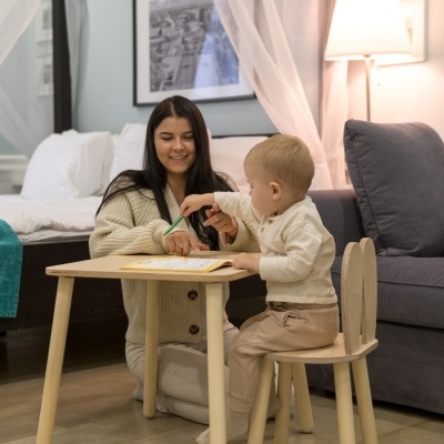 Mesa e cadeira de madeira clara com design simples e encosto em forma de orelhas em sala acolhedora