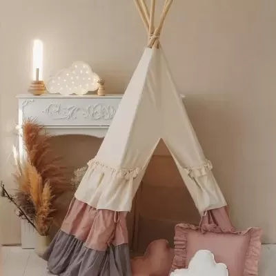 Tenda de criança em tecido colorido com almofadas e candeeiro decorativo em ambiente interior
