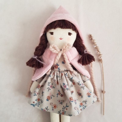 Boneca de pano com casaco rosa e vestido floral