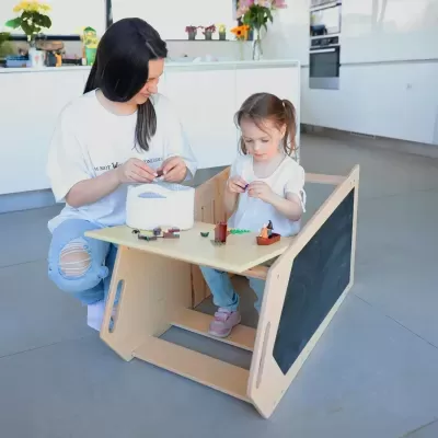 Estrutura de madeira multifuncional para crianças com quadro negro e mesa integrada.