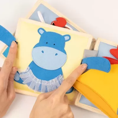 Livro infantil de tecido com hipopótamo azul e galinha amarela