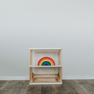 Prateleira branca em madeira clara com arco-íris colorido dentro