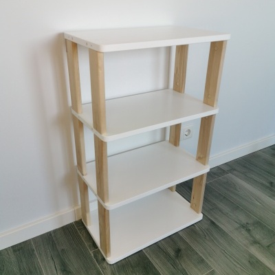 Estante de madeira branca e clara com quatro prateleiras em parede branca
