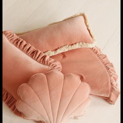 Três almofadas rosas claras, incluindo uma concha e duas retangulares com bordas franzidas e pêlo sintético.