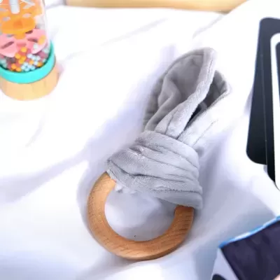 Mordedor de bebé de madeira com tecido cinzento macio