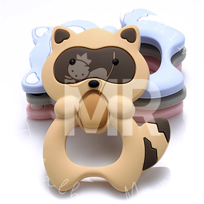 Chave de silicone em forma de guaxinim sobre outras peças coloridas