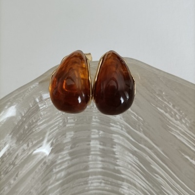 Brincos clip âmbar com detalhes dourados sobre base de vidro