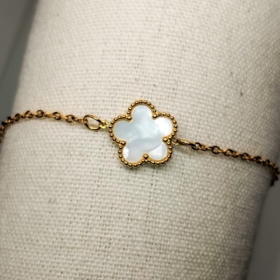 Pulseira dourada com pendente de flor em madrepérola