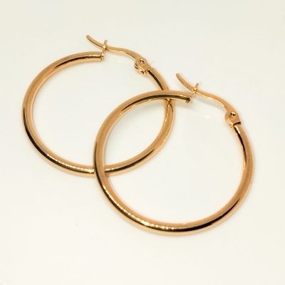 Par de brincos de argola dourados em fundo branco