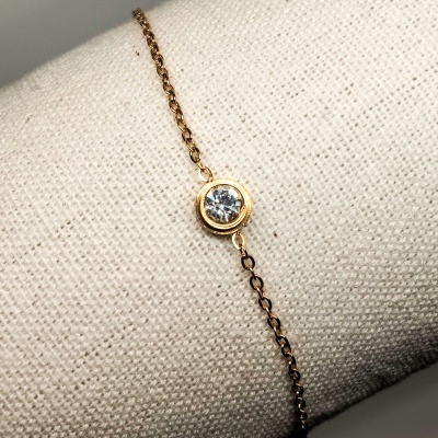 Pulseira fina dourada com pedra transparente redonda