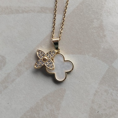 Colar dourado com pendente de flor branca e cristais