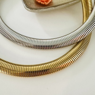 Colares rígidos dourado e prateado com textura de linhas verticais sobre fundo branco