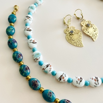 Colares de contas coloridas e brincos dourados em forma de folhas