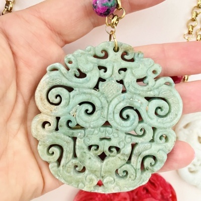 Colar com pendente verde entalhado e corrente dourada com contas coloridas