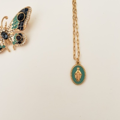 Colar dourado com pendente oval verde e figura religiosa e broche borboleta colorido