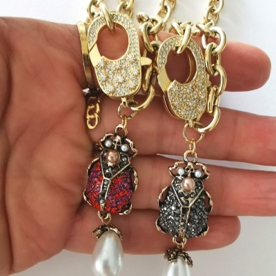 Colares dourados com pendentes de abelha e pérolas