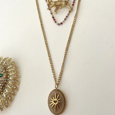 Colares dourados com pingentes de sol, tigre e folhas decorativas