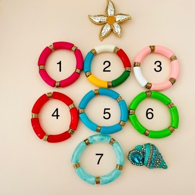Sete pulseiras coloridas numeradas e dois pendentes decorativos sobre fundo claro