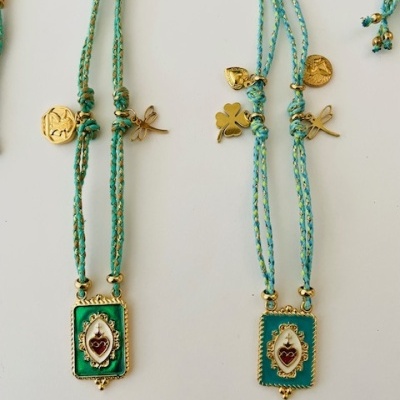 Colares com pendentes retangulares verdes e amuletos dourados em cordão azul e verde