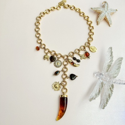 Colar dourado com múltiplos pendentes coloridos e enfeites ao lado