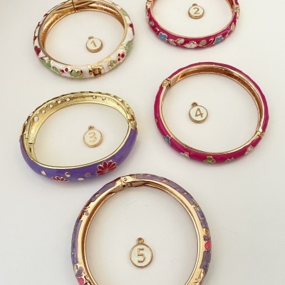 Cinco pulseiras coloridas com padrões florais e números em fundo branco