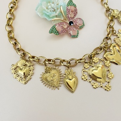 Colar dourado com corações pendentes e broche de borboleta com flor azul