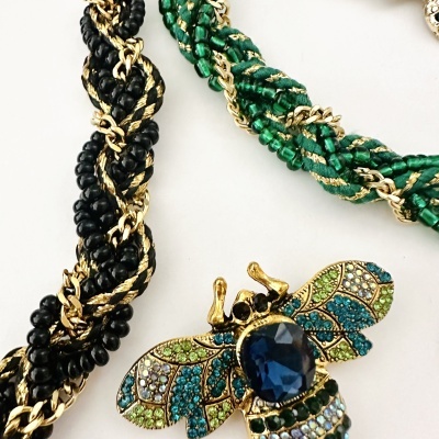 Bijuterias com colares trançados e pêndulo em forma de abelha colorida