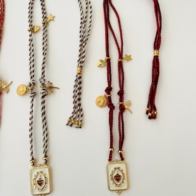 Colares trançados cinza e vermelho com pendentes e medalhas douradas numeradas