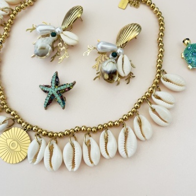 Jóias com conchas, ouro metálico, pérolas e detalhes verdes e azuis