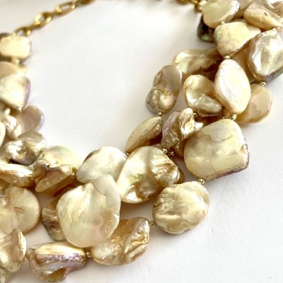 Colar artesanal com pedras naturais douradas e corrente metálica.