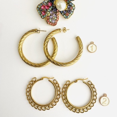 Brincos dourados em argolas torcidas e com padrão de elos, com broche de flor colorida com cristais e pérola.