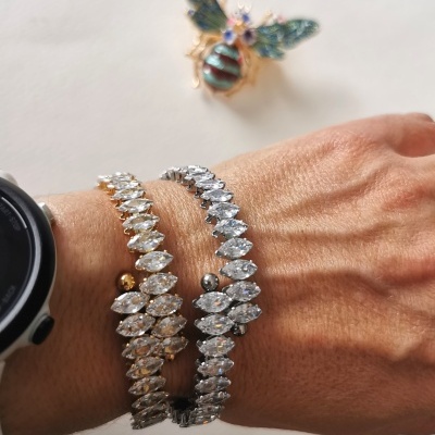 Braçadeiras brilhantes com pedras transparentes e broche de abelha colorida