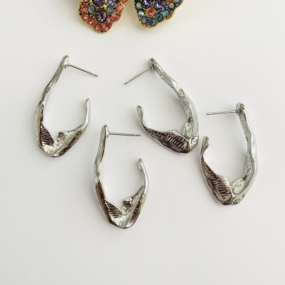 Conjunto de brincos prateados e broche colorido com pérola