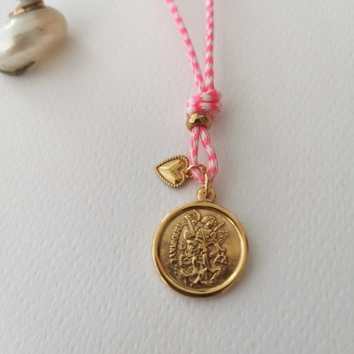 Colar com pendentes dourados em cordão rosa e branco sobre fundo branco