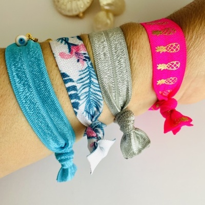 Pulseiras elásticas em pano coloridas com padrões variados no pulso