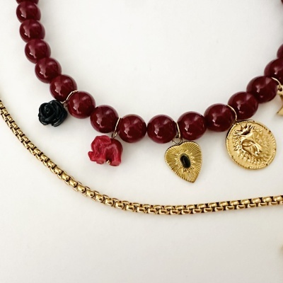 Colar com contas vermelhas e pendentes decorativos variados e corrente dourada