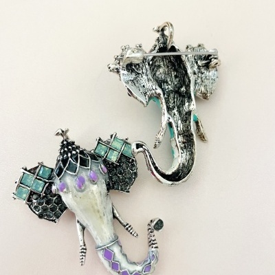 Par de broches em forma de elefante com detalhes coloridos e textura metálica